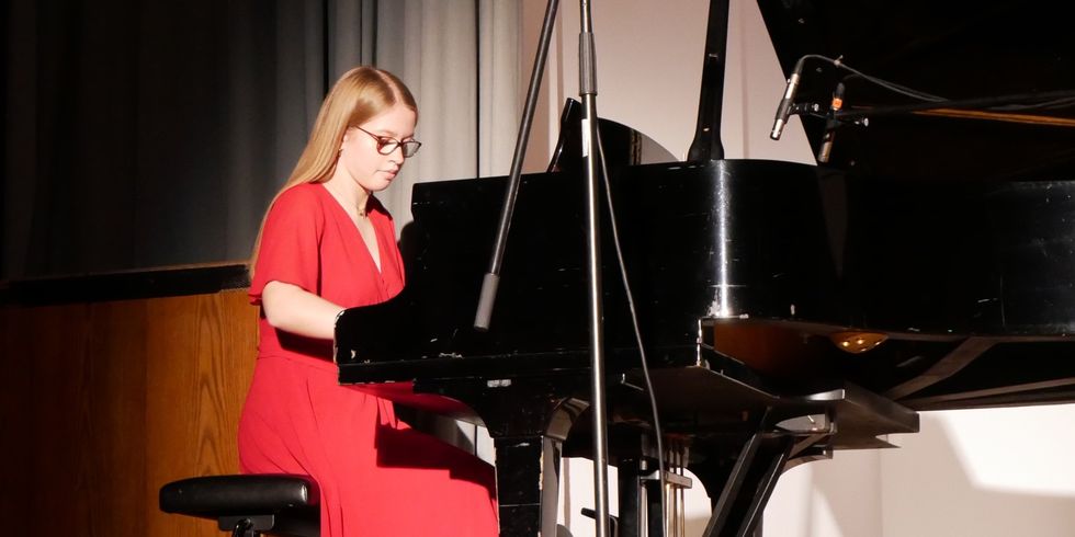 Mädchen sitzt am Flügel