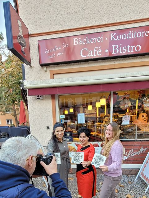 Emine Demirbüken-Wegner (CDU, Mitte) bringt mit Manuela Seefluth (rechts) und der Einsamkeitsbeauftragten Katharina Schulz den Sticker gegen Einsamkeit an (Bild: BA Reinickendorf)