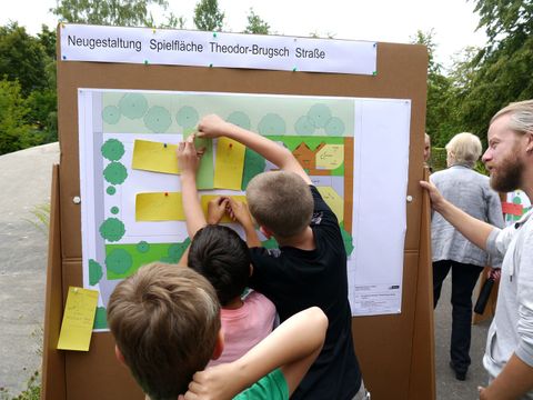 Kinder pinnen Zetel an Sttellwand mit Plänen