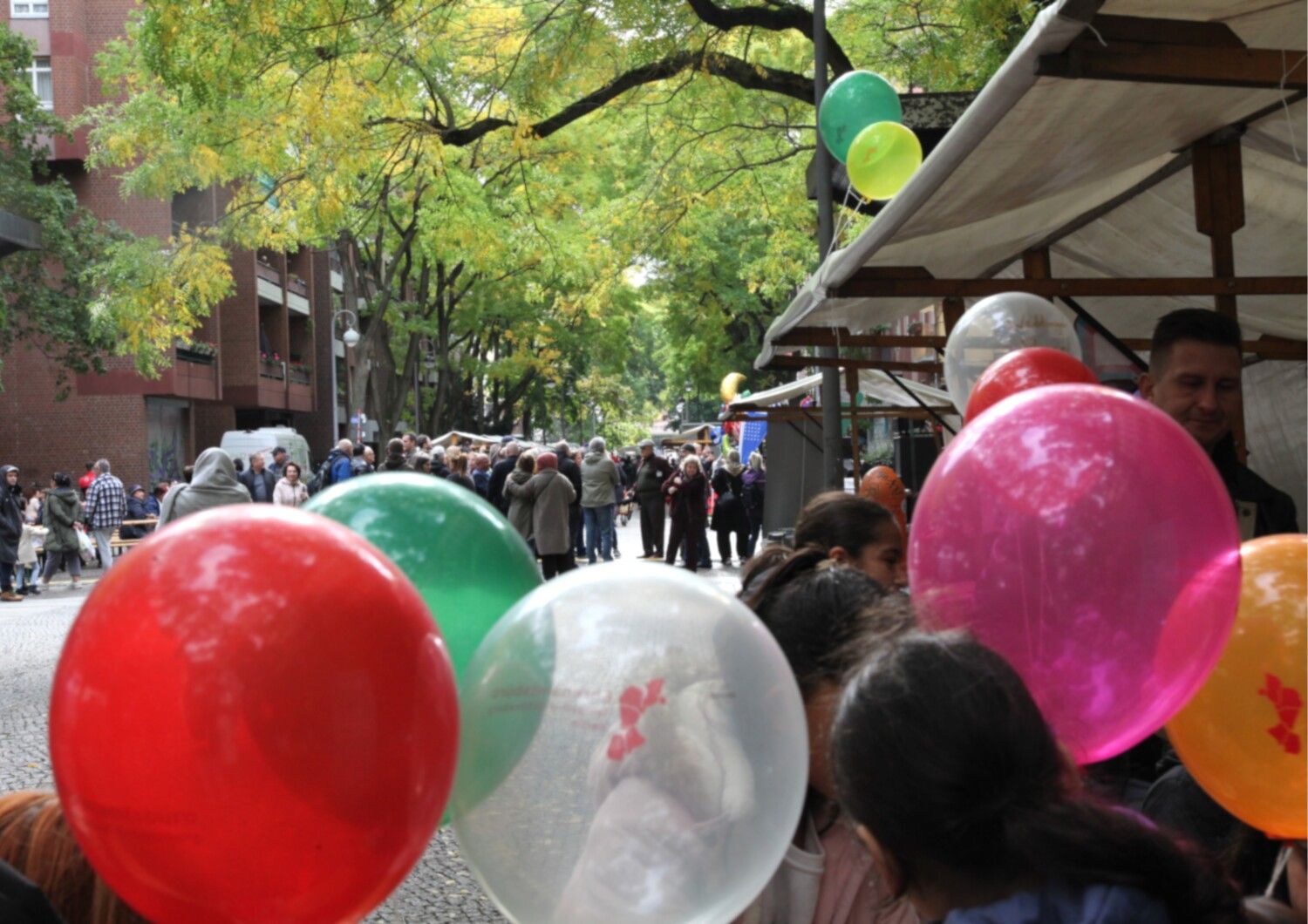 Luftballons und Menschen in der einer Straße