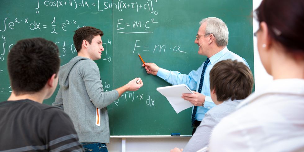 Schüler mit Lehrer im Klassenraum beim Mathematikunterricht
