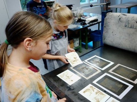 Malen – Zeichnen – Drucken: Kinder stehen um die Tiefdruckpresse in der Druckwerkstatt. (Bild: © Jugendkunstschule Pankow)
