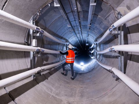 Ein Techniker steht in einem Kabeltunnel unter Berlin