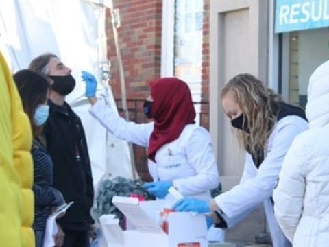 Eine Ärztin führt bei einem Mann einen Corona-Abrstrich durch.