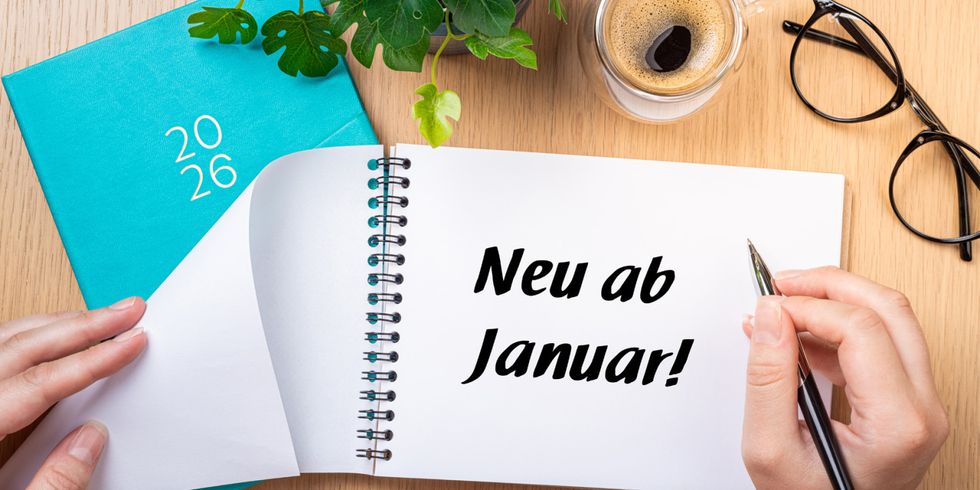 Ein weißer Block mit der Aufschrift "Neu ab Januar!" liegt auf einem Schreibtisch