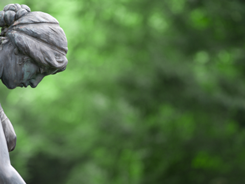 Frauenstatue aus Stein auf einem Friedhof