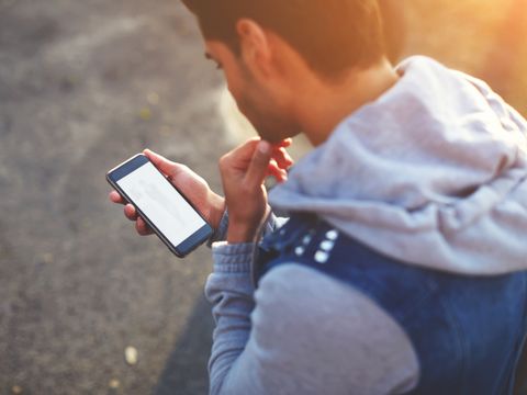 Junger Mann schaut auf sein Smartphone