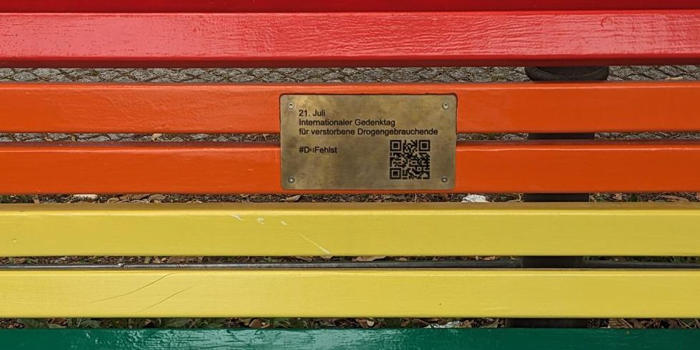Inschrift auf der Bank am Oranienplatz: „21. Juli Internationaler Gedenktag für verstorbene Drogengebrauchende. #Dufehlst“