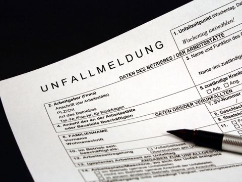 Unausgefülltes Unfallmeldungsformular mit daraufliegendem Stift