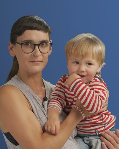 Auf dem Bild ist eine Alleinerziehende mit ihrem Sohn auf dem Arm in einer Interview Situation zu sehen