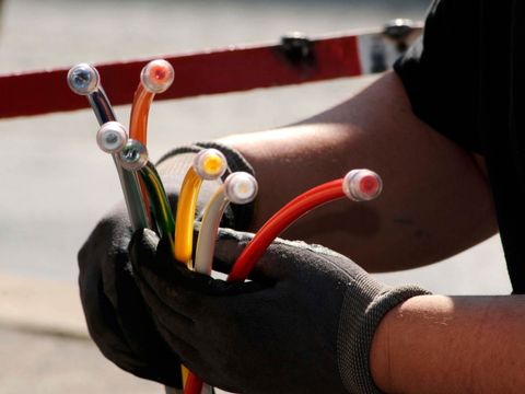 Techniker mit bunten Glasfaserkabeln für schnelles Breitband-Internet