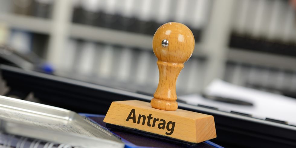 Stempel mit der Aufschrift 'Antrag' steht auf einem Stempelkissen