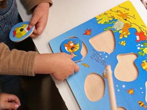 Kind setzt ein Teil in ein Holzpuzzle ein
