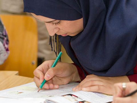 Lernende mit Stift über Buch gebeugt