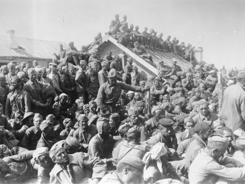 eine dichte Menschenmenge, die sich zum Teil auch auf dem Dach eines kleinen Gebäudes befinden.