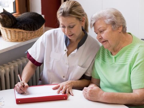 Altenpflegerin beim Hausbesuch einer Patientin