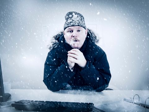 Mann mit Winterjacke und Mütze friert