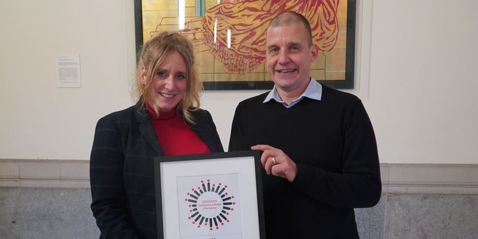 Bezirksbürgermeisterin Kirstin Bauch und Christian Sauer, Leiter der Service-Einheit Finanzen, Personal und Steuerungsdienst mit dem GfA-Gütesiegel.