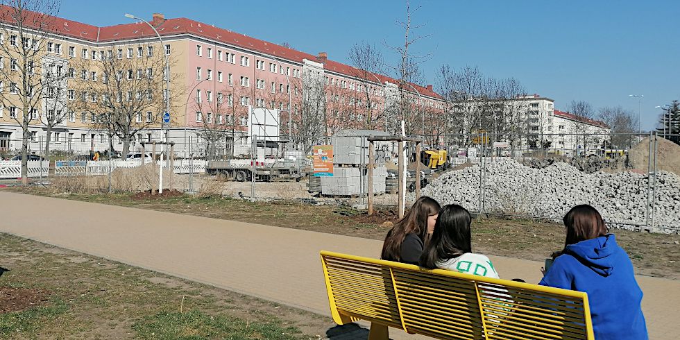 Mädchen auf der Bank vor Baustelle Werneuchener Wiese