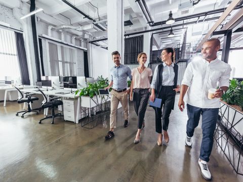 Lächelnde junge Geschäftskollegen, die im Büro reden
