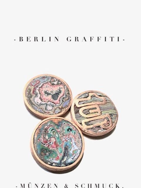 DRei farbenfrohe Münzen mit Goldrand