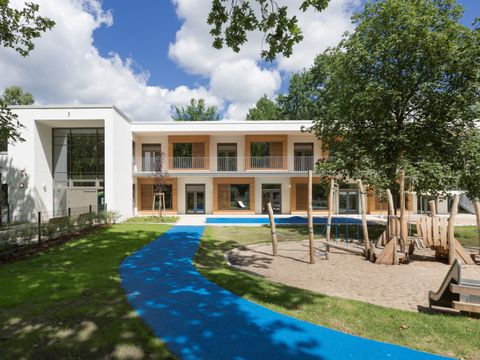Gartenfassade der zweistöckigen Kita Regenbogen
