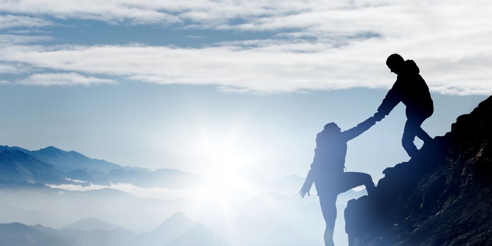 Bergsteiger helfen einander, den Gipfel zu erreichen