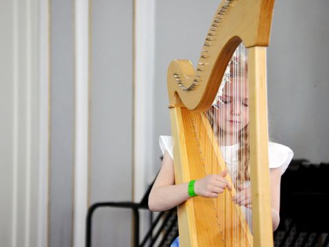 Kleine Harfenspielerin beim besonderen Konzert im Schlosspark