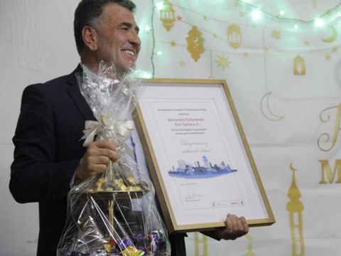 Muammer Yeşil, Vorstand des Islamischen Kulturvereins Emir Sultan e.V., mit einem Geschenk des Bezirksamtes