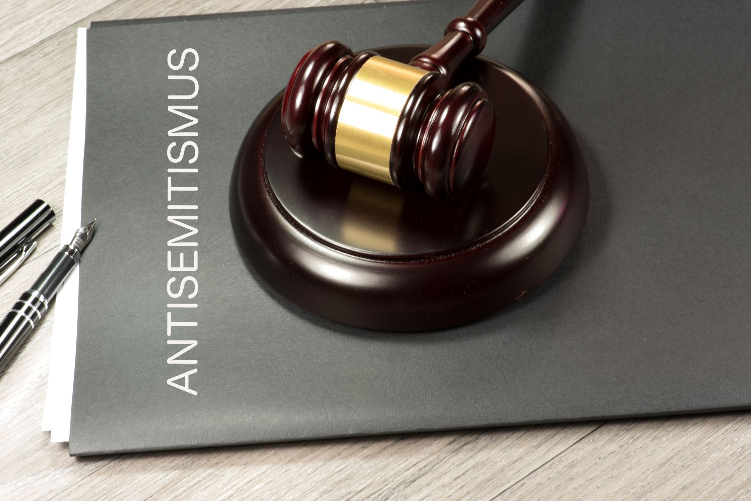 ein Justiziar-Hammer liegt auf einer Mappe mit Aufschrift Antisemitismus
