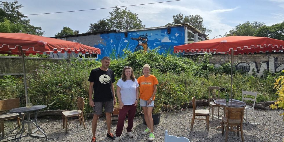 Dunja und Lothar Zech stehen gemeinsam mit Clara Herrmann (Mitte) vor dem Eisvogel-Grafitti des Künstlers Marc Seven im Naturgarten-Café am Ostkreuz
