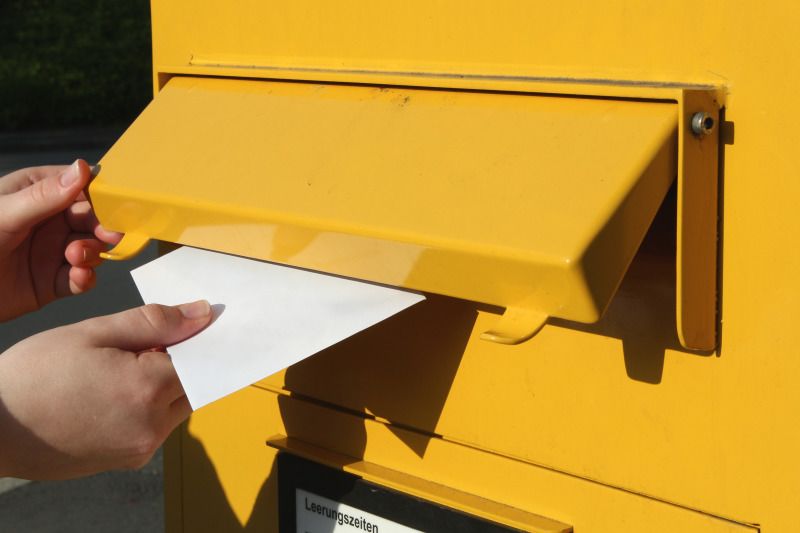 Brief wird in Briefkasten eingeworfen