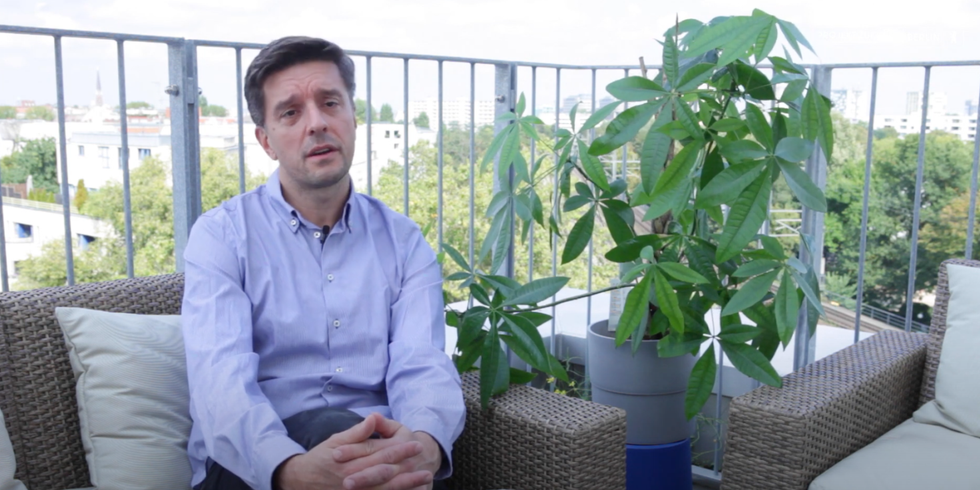 Enrico sitzt auf einer Couch auf einer Terrasse