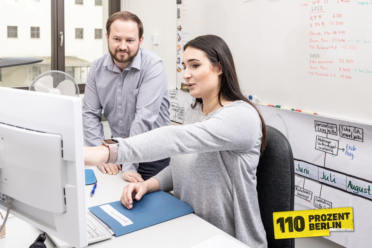 Mitarbeitende vor einem PC am diskutieren