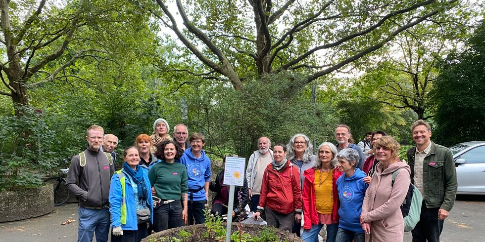 Gruppenbild vor dem neu bepflanzten Riesenblumentopf in der Dessauer Straße