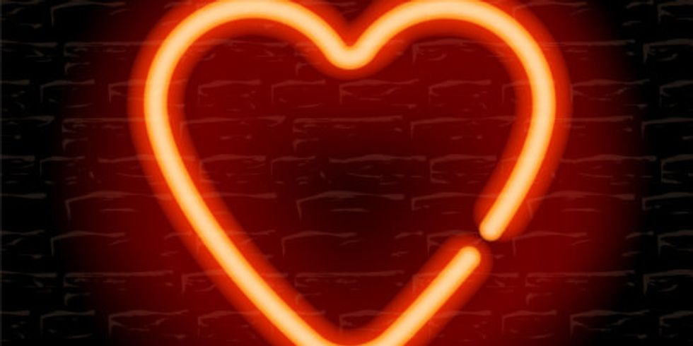 Rotes, Neon-Herz vor einer schwarzen Wand