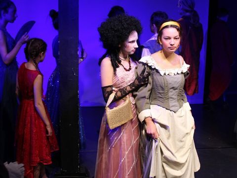 Theater „Zauberhafte Verwandlung“: Kinder in Kostümen spielen eine Szene auf der Bühne.