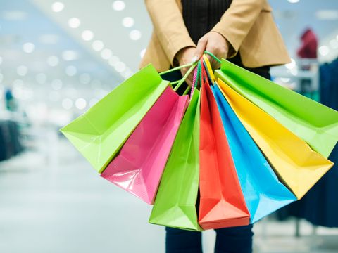 eine Person hält viele bunte Geschenketüten in den Händen