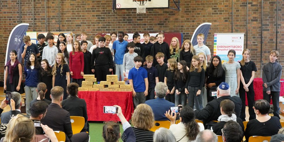 eine große Gruppe von Kindern steht auf einer Bühne