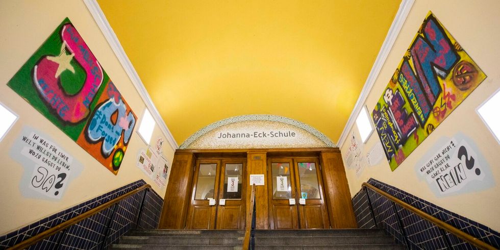 Im Eingangsportal der Johanna-Eck-Schule sind Graffitis sowie Fotos und Texte zu sehen.