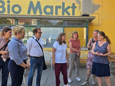 Geschäftsführer Dieter Kuhn (mi.) begrüßt die Gruppe gemeinsam mit Warenwirschaftsprofi Manuela Kamata (re.) im Hof des LPG BioMarkts