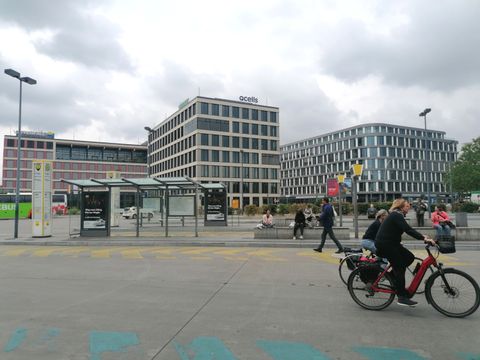 Hildegard-Knef-Platz mit Radfahrender und Neubauten im Hintergrund