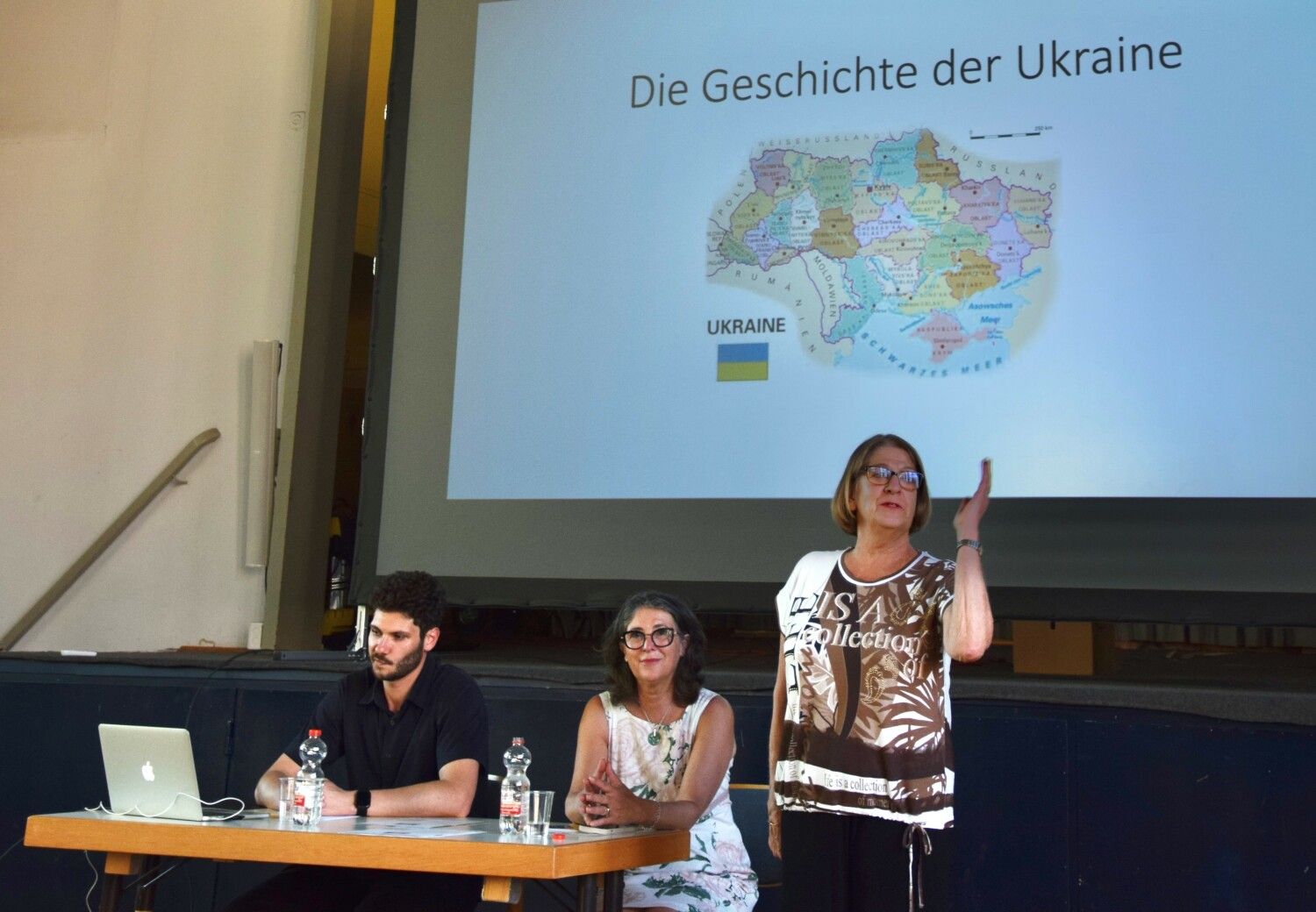 Ukraine-Veranstaltung des Städtepartnerschaftsvereins am 23. Juni 2022. Rechts neben dem Referenten stehend Vereinsvorsitzende Gisela Pflug und sitzend Vorstandsmitglied Olga Pischel