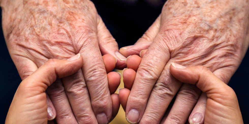 Die Hände einer Frau spenden Kraft und Trost, und die eines älteren Herrn