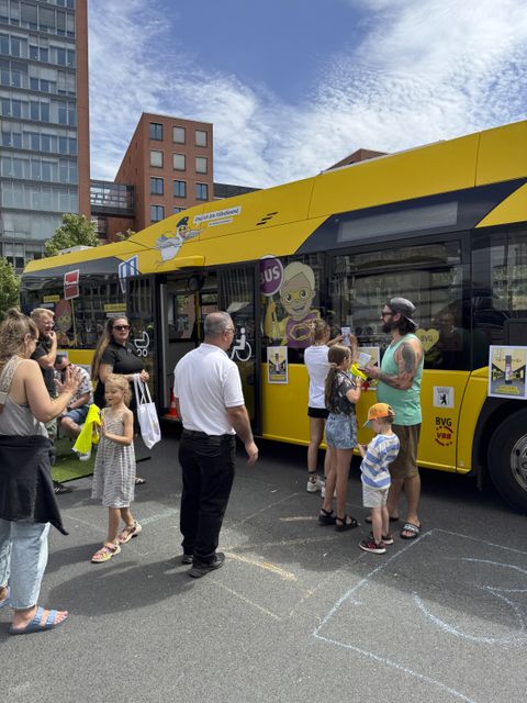 Kinder mit Eltern vor einem Bus