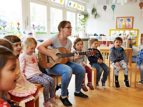 Erzieherin singt mit Kitakindern