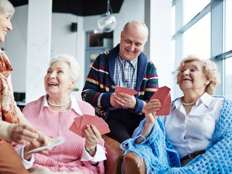 Seniorengruppe, drei Frauen und ein Mann, beim Kartenspielen