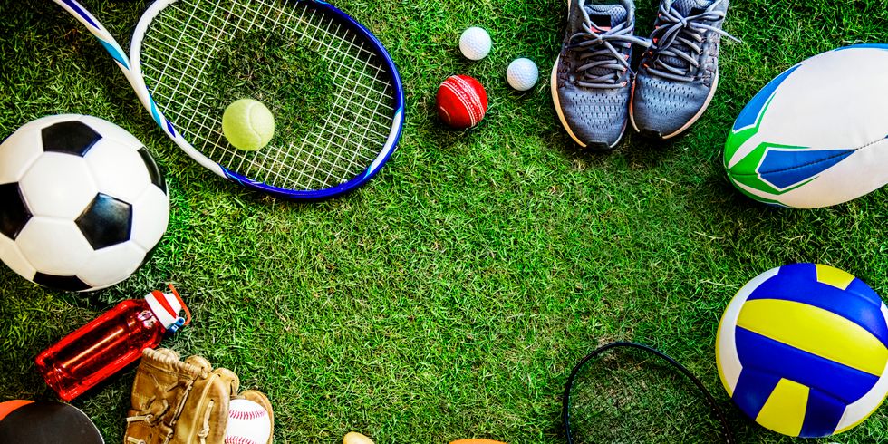 Verschiedene Sportgeräte wie Schläger und Bälle liegen auf dem Rasen