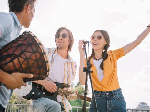 junge Menschen spielen Instrumente und singen im Freiem