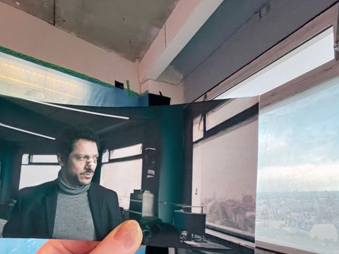 Bierpinsel - Dogs of Berlin: Hand hält Foto einer Filmszene mit Fahri Yardım in die passende Kulisse des Drehorts